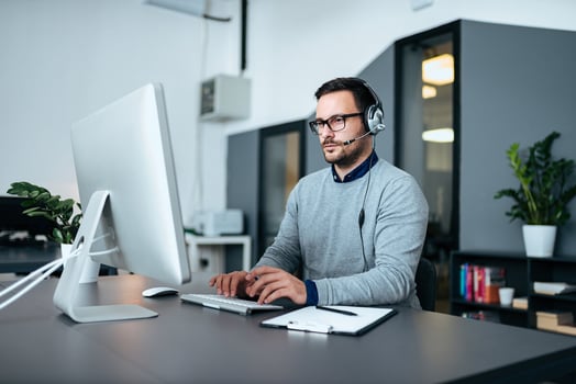 Incident management process: IT support wearing a headset while typing