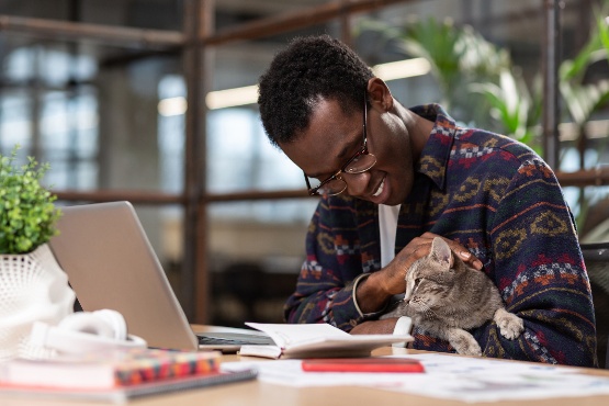 Man holding cat at desk