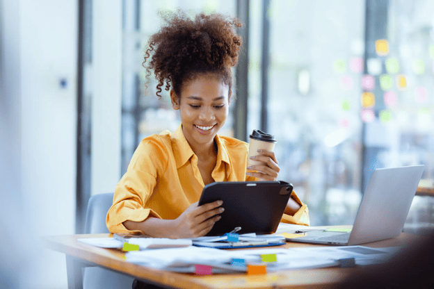 Entrepreneur using a tablet while holding a cup of coffee