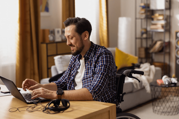 ADA leave vs FMLA: person in a wheelchair happily typing on his laptop