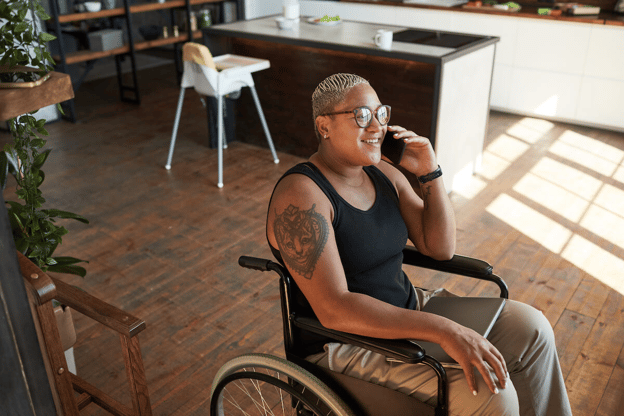 Woman sitting on a wheelchair while talking on the phone